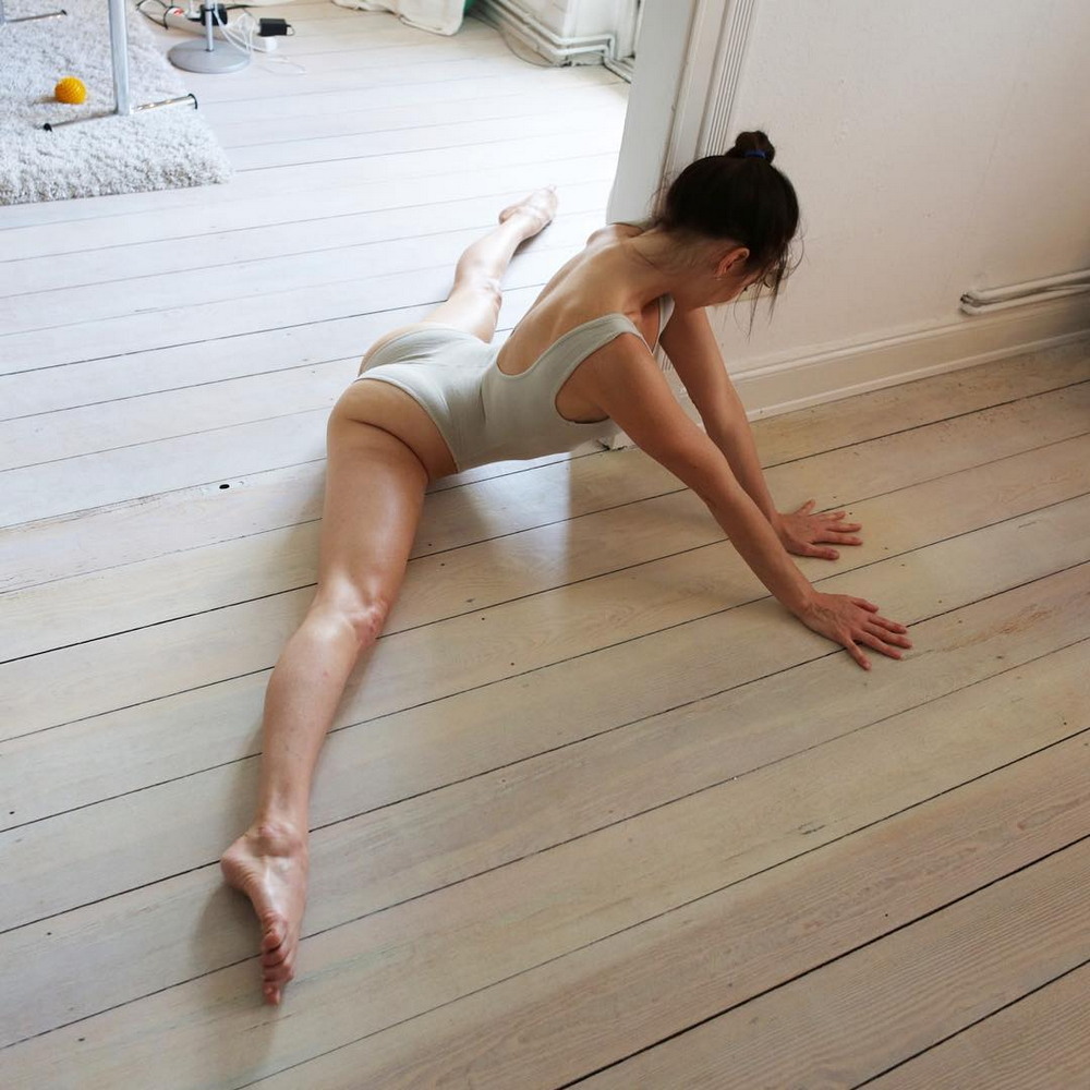 Смазливая спортсменка широко раздвигает ножки на полу