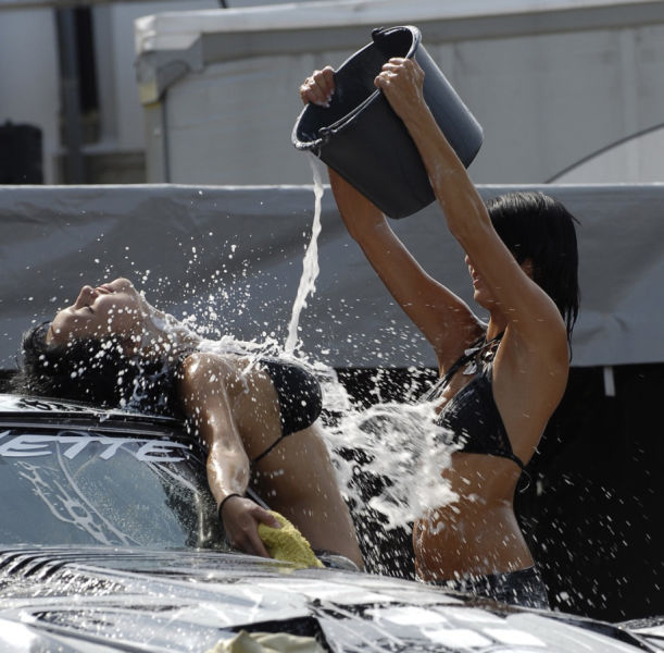 Красивые девушки в купальниках моют автомобили