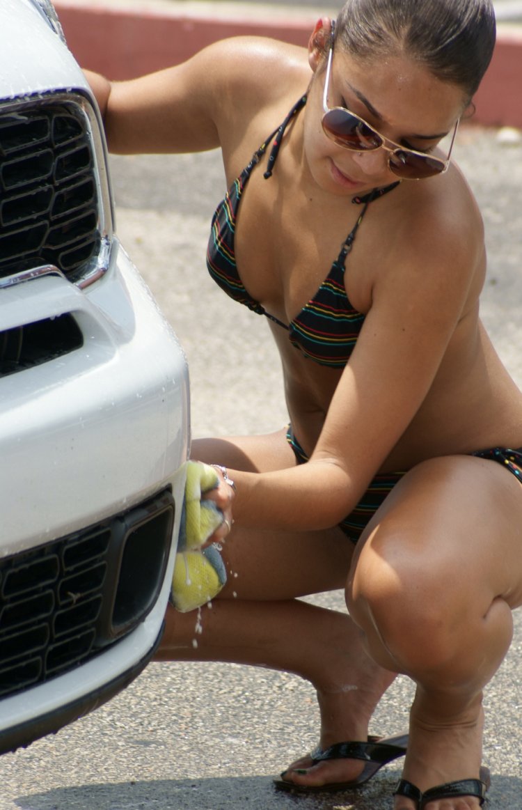 Красивые девушки в купальниках моют машины