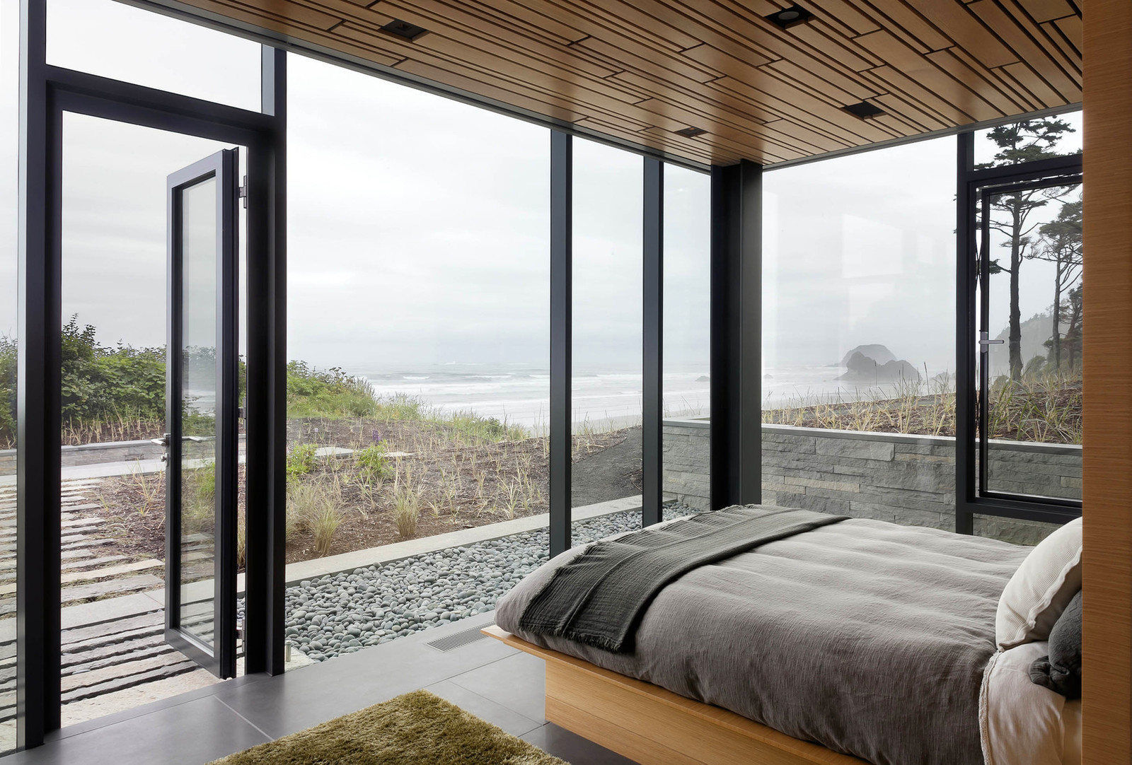 Интерьер комнаты в черном стиле с панорамными окнами с видом океана
