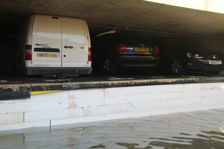 Поднявшийся от наводнения пол расплющил оставленные на парковке машины