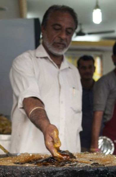 Индийский повар жарит рыбу в кипящем масле голыми руками