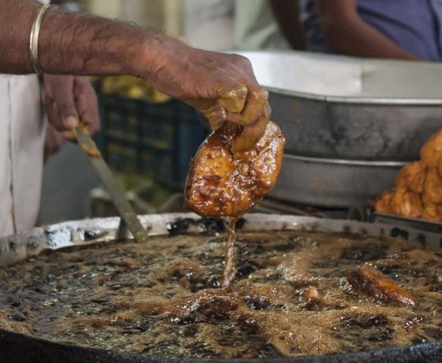 Индийский повар жарит рыбу в кипящем масле голыми руками