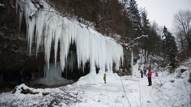 Скала с замерзшим водопадом привлекает толпы туристов