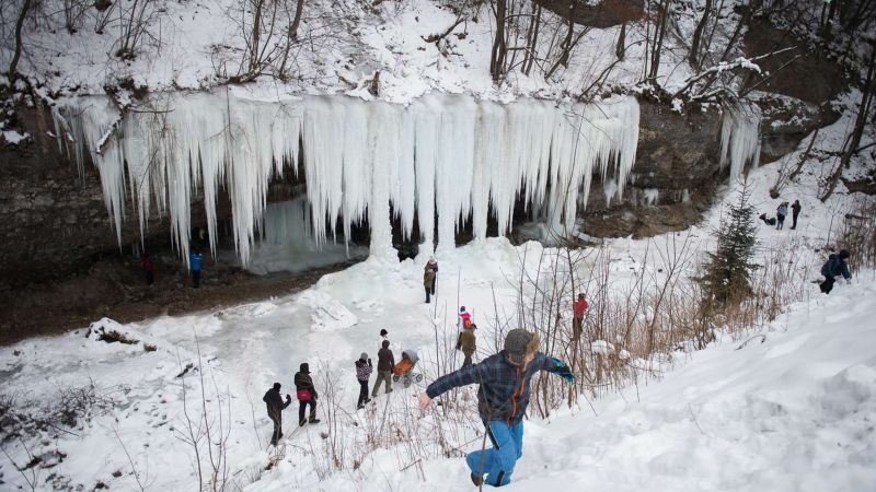 Скала с замерзшим водопадом привлекает толпы туристов