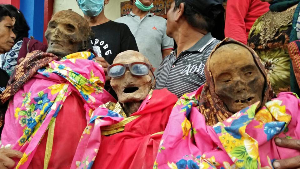 Туристы позируют на индонезийском фестивале мертвых родных