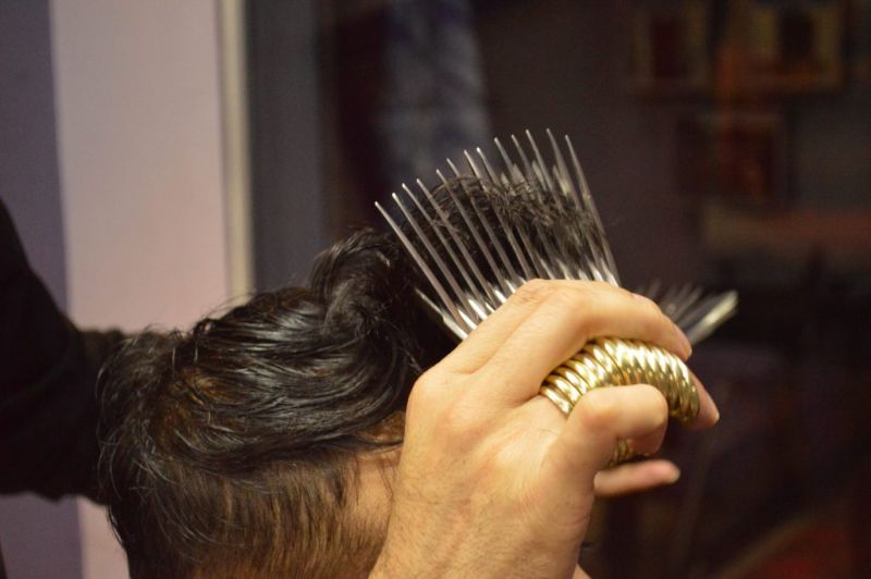 Парикмахер стрижет клиентов одновременно 27 парами ножниц