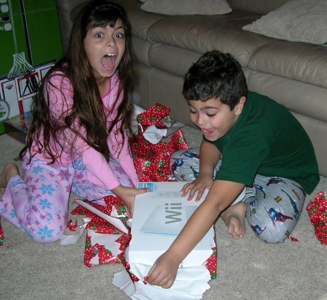 Счастливые дети получают новогодние подарки