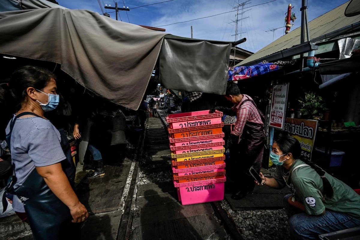 Удивительный рынок Mae Klong на железнодорожных путях в Таиланде