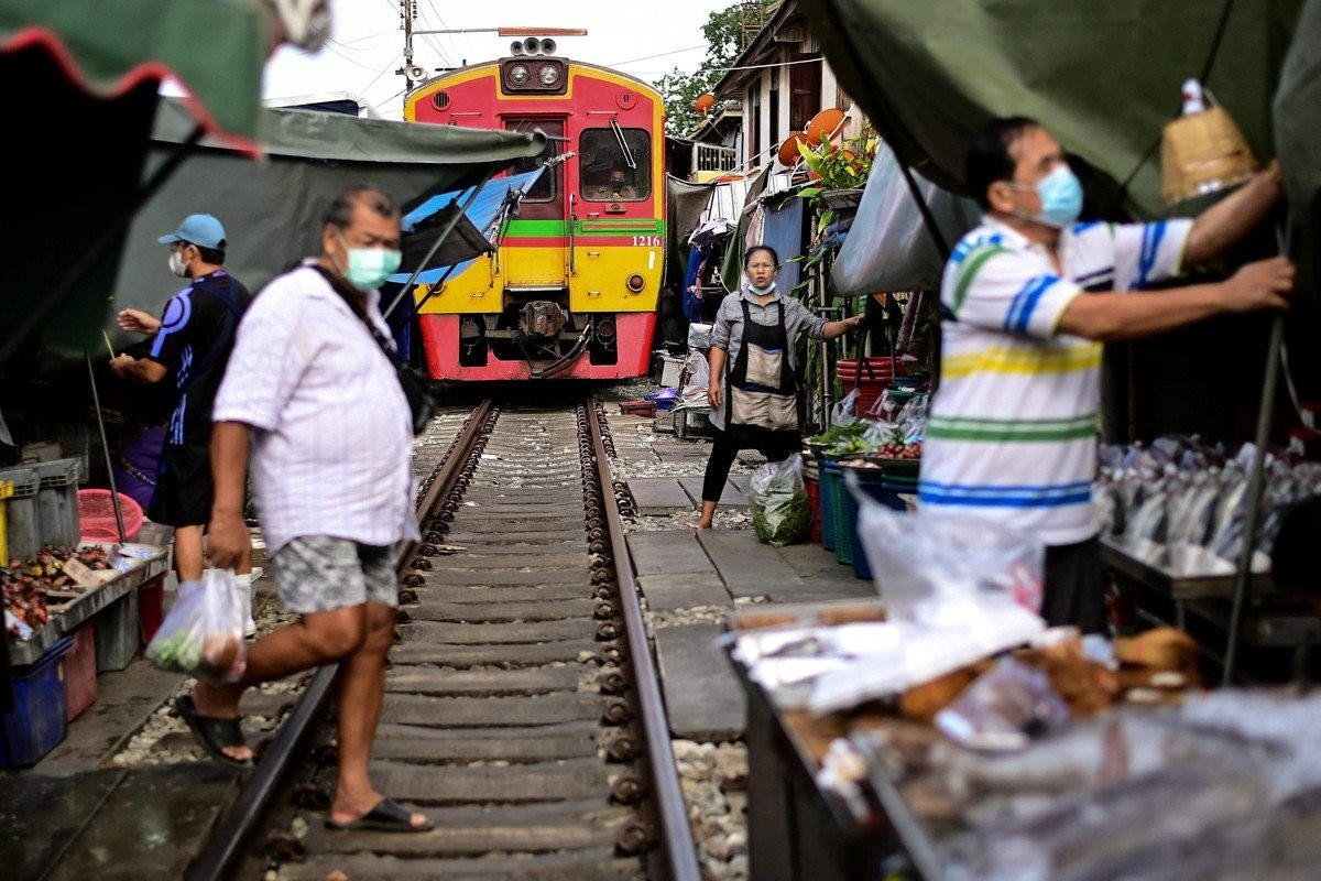 Удивительный рынок Mae Klong на железнодорожных путях в Таиланде