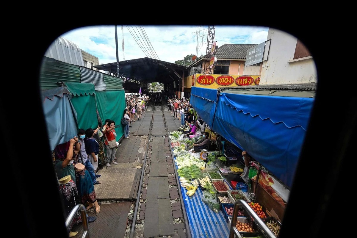 Удивительный рынок Mae Klong на железнодорожных путях в Таиланде