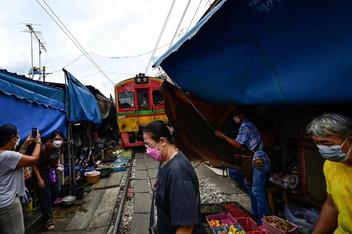 Удивительный рынок Mae Klong на железнодорожных путях в Таиланде