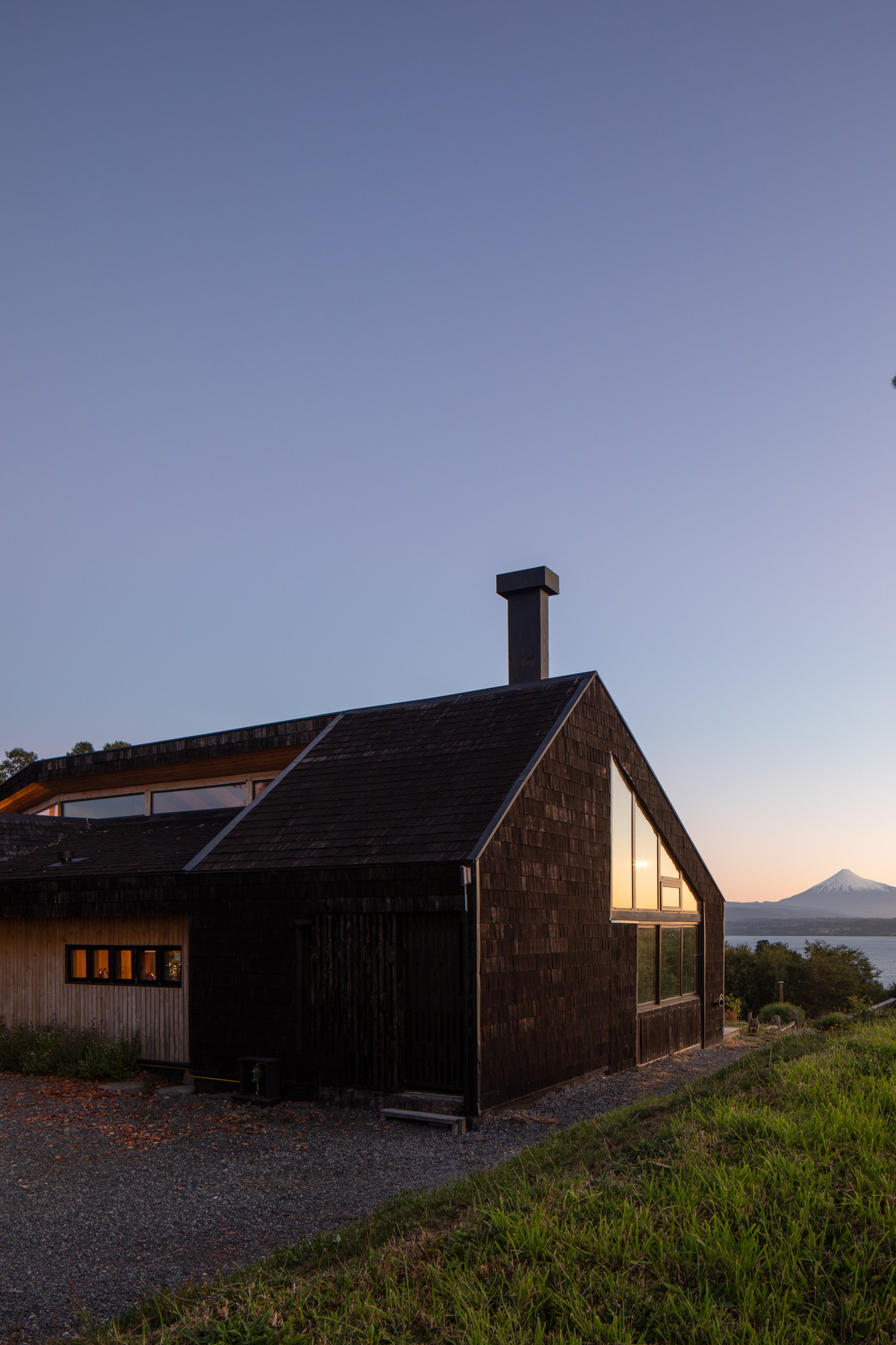 Деревянный дом на холме на берегу озера в Чили