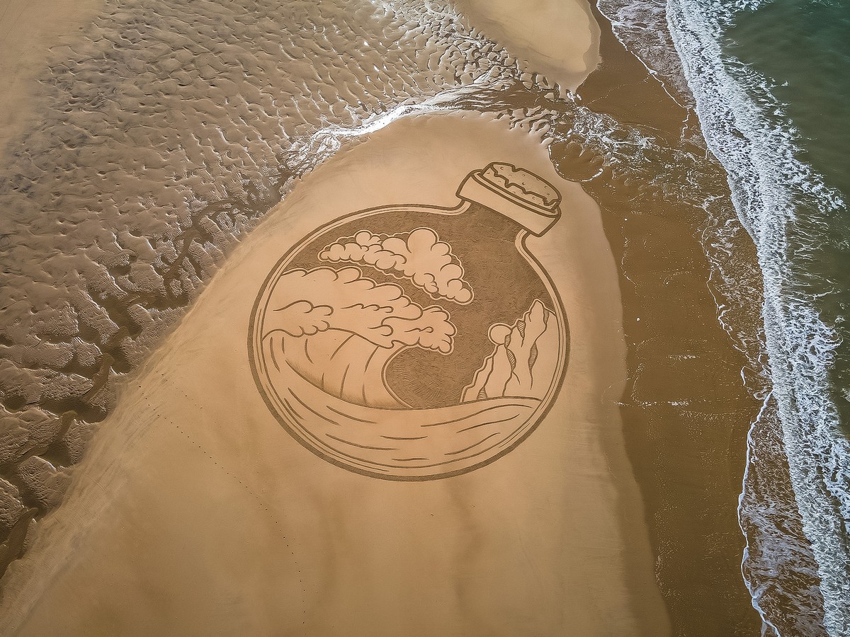 Художник создает гигантские рисунки на пляжном песке