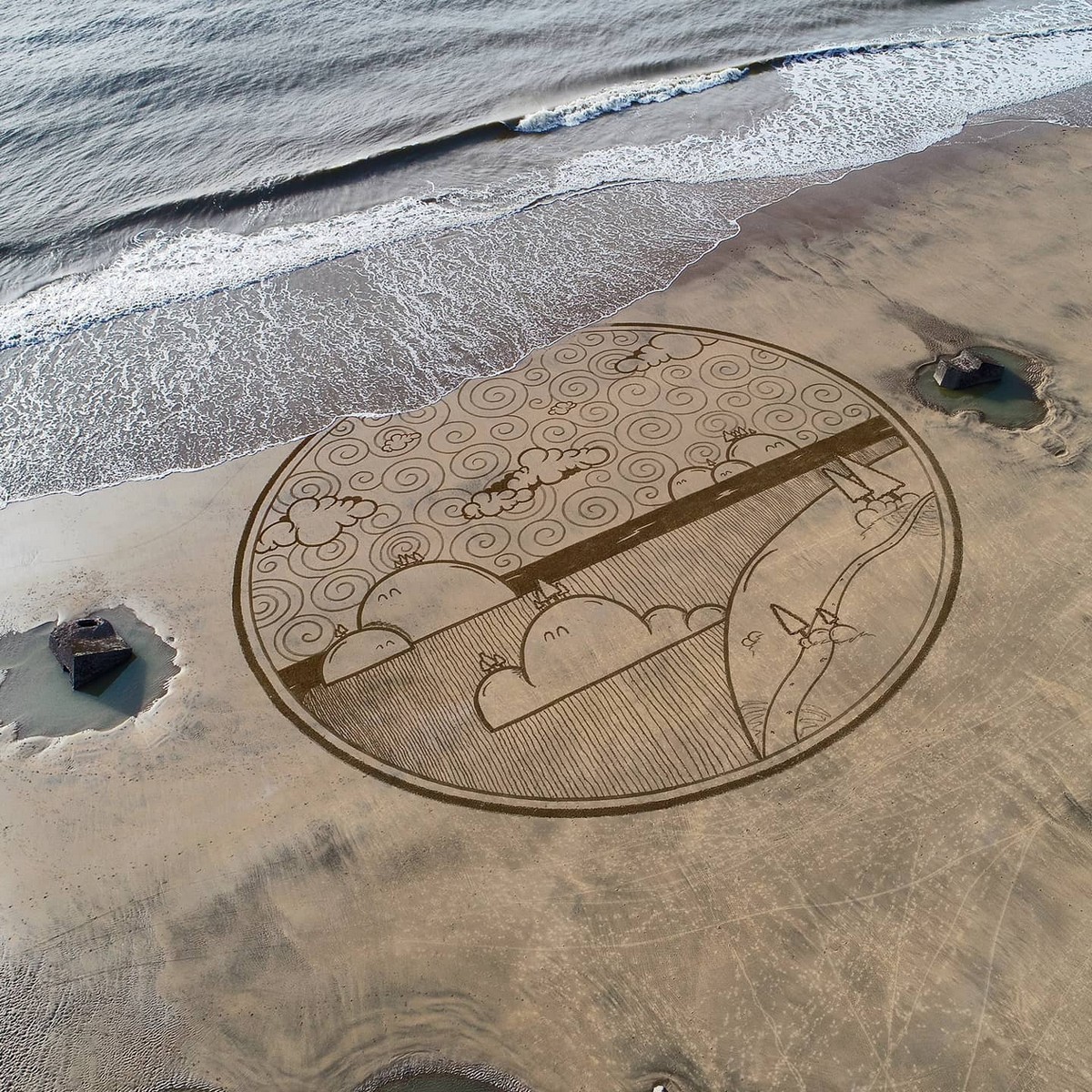 Художник создает гигантские рисунки на пляжном песке